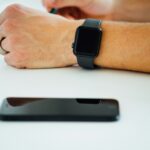 “직장인 건강, 스마트하게 챙기자: 웰니스 트렌드로 사무실이 바뀐다” black smartphone near person's hand wearing black smartwatch