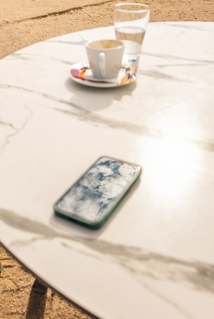 Smartphone and coffee cup on marble table
