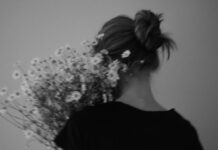 직장인 ‘마음 챙김 루틴’, 현명하게 일상에 녹이기 A person in a black shirt holding a bouquet of daisies